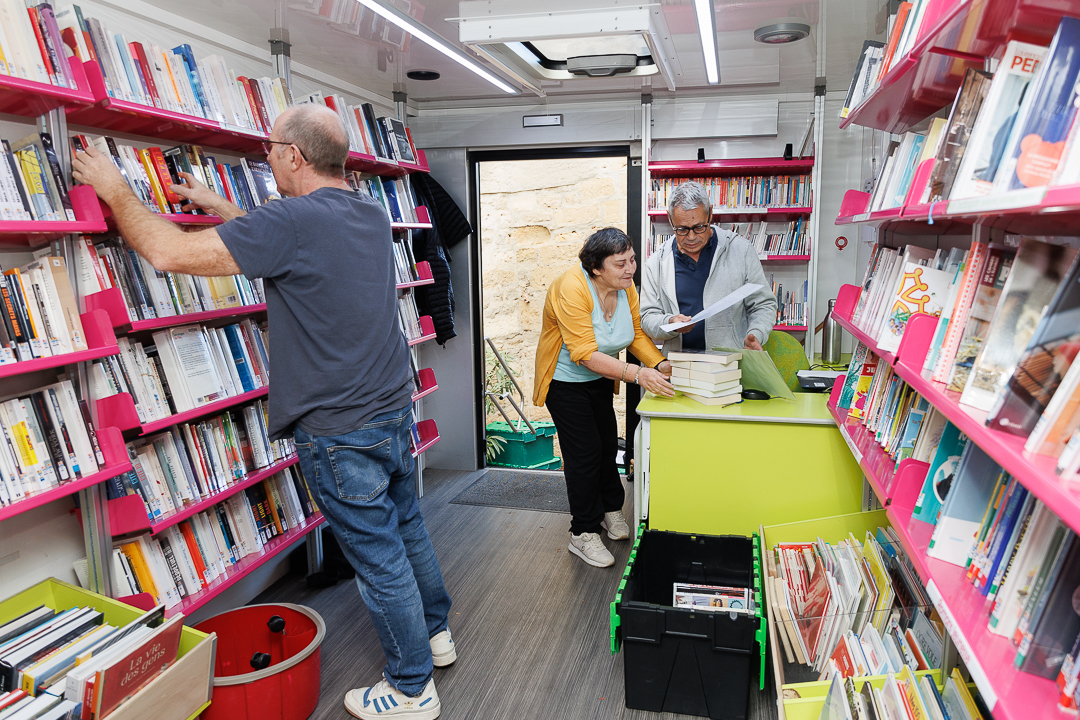 des personnes empruntent dans un bibliobus