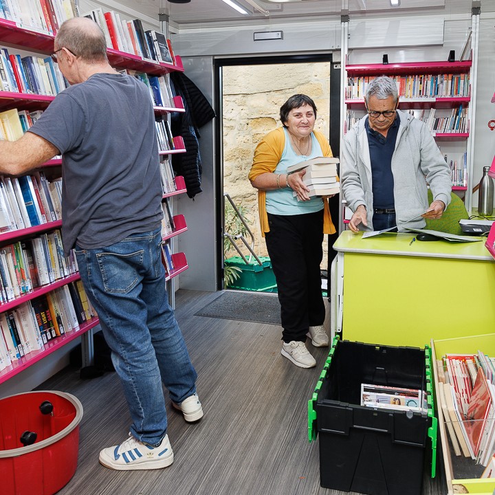 une bibliothécaire choisit des livres dans le bibliobus