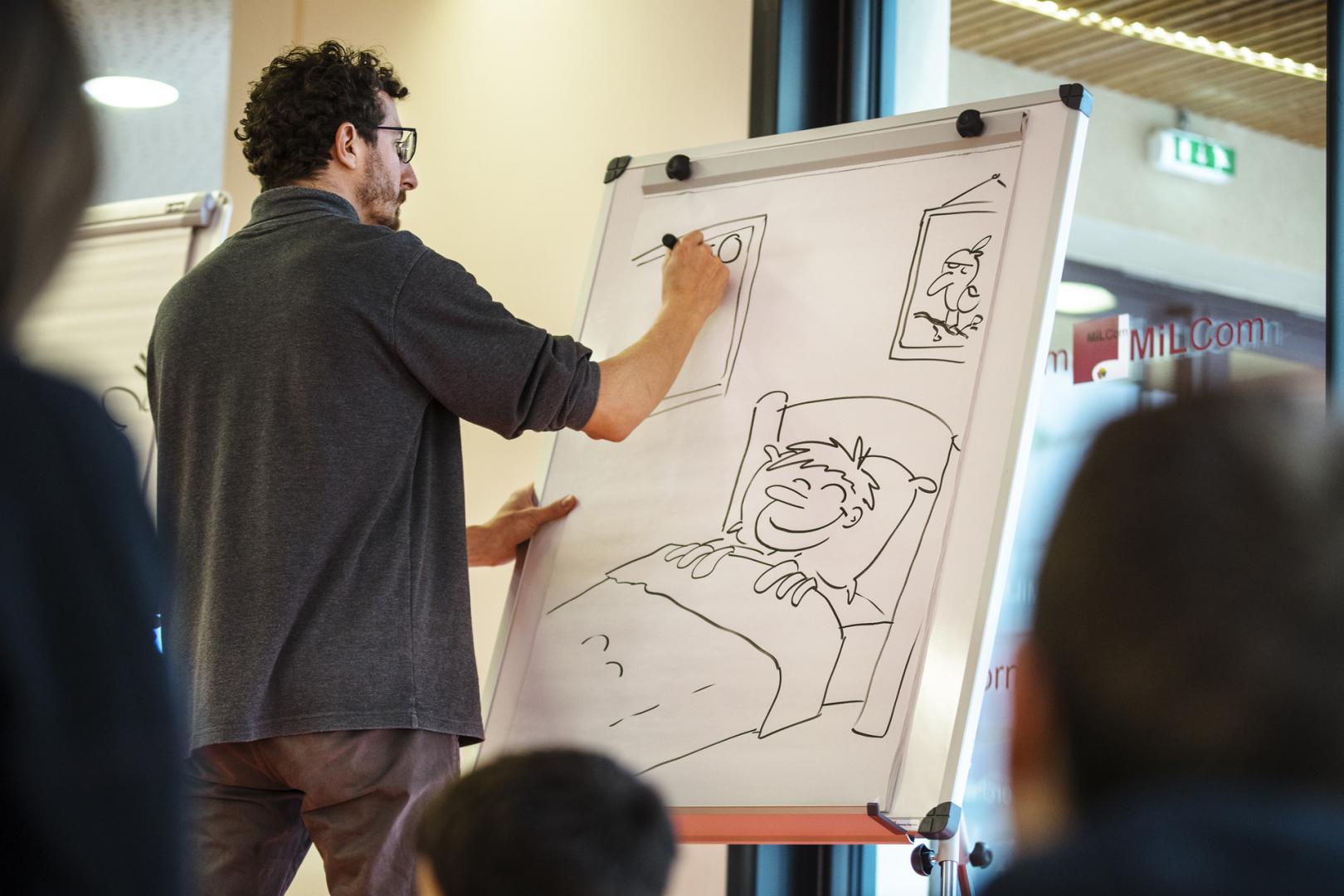 un illustrateur dessine lors d'une performance publique