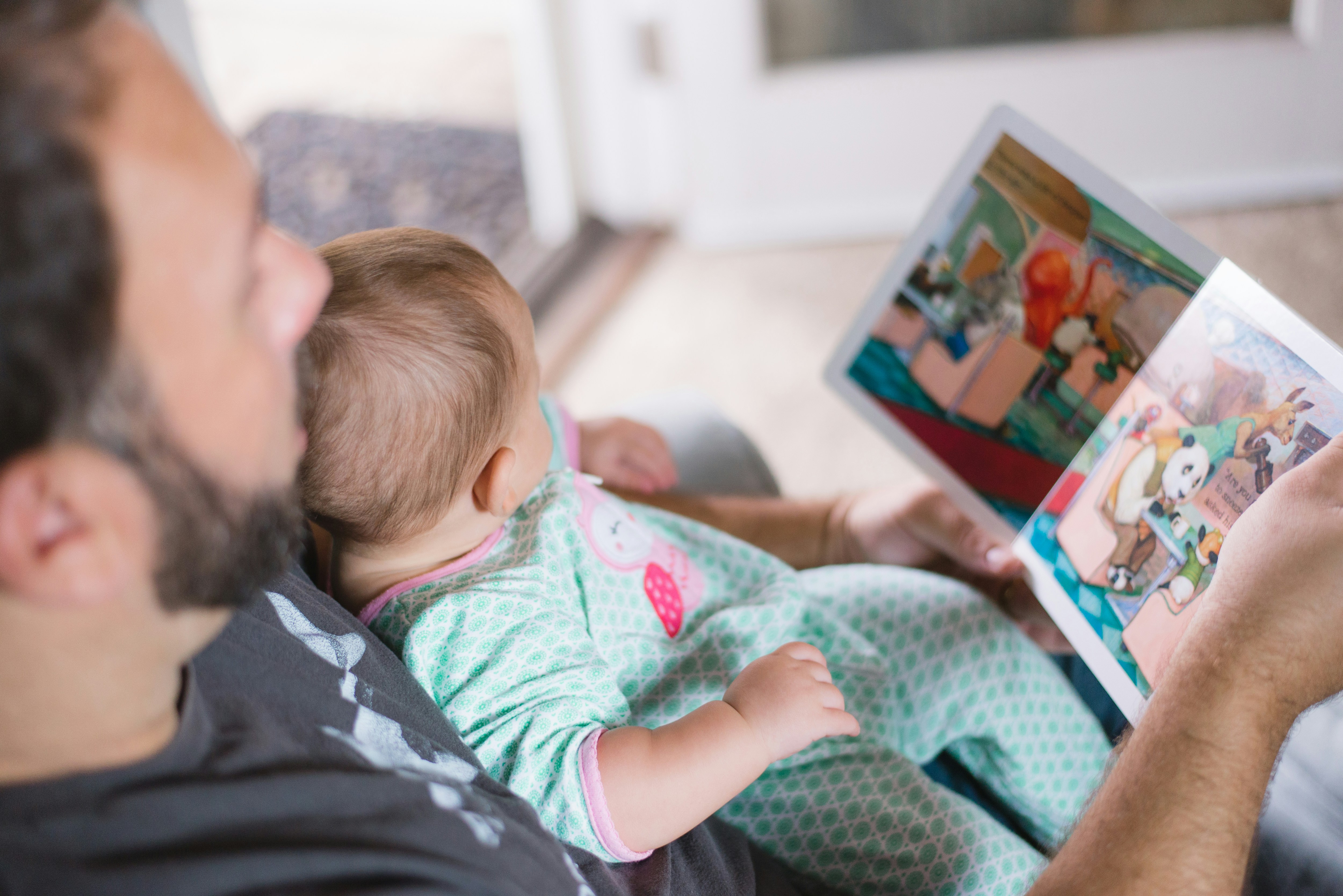 un bébé lit un livre avec son papa